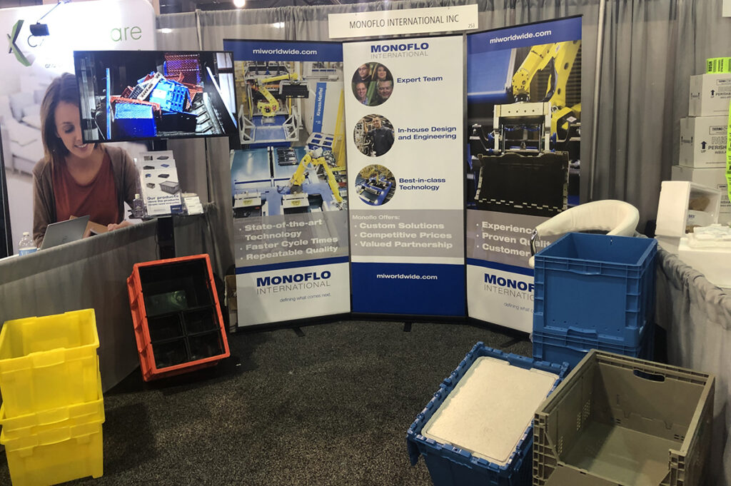 A trade show display featuring various plastic containers and items arranged for attendees to view and explore.